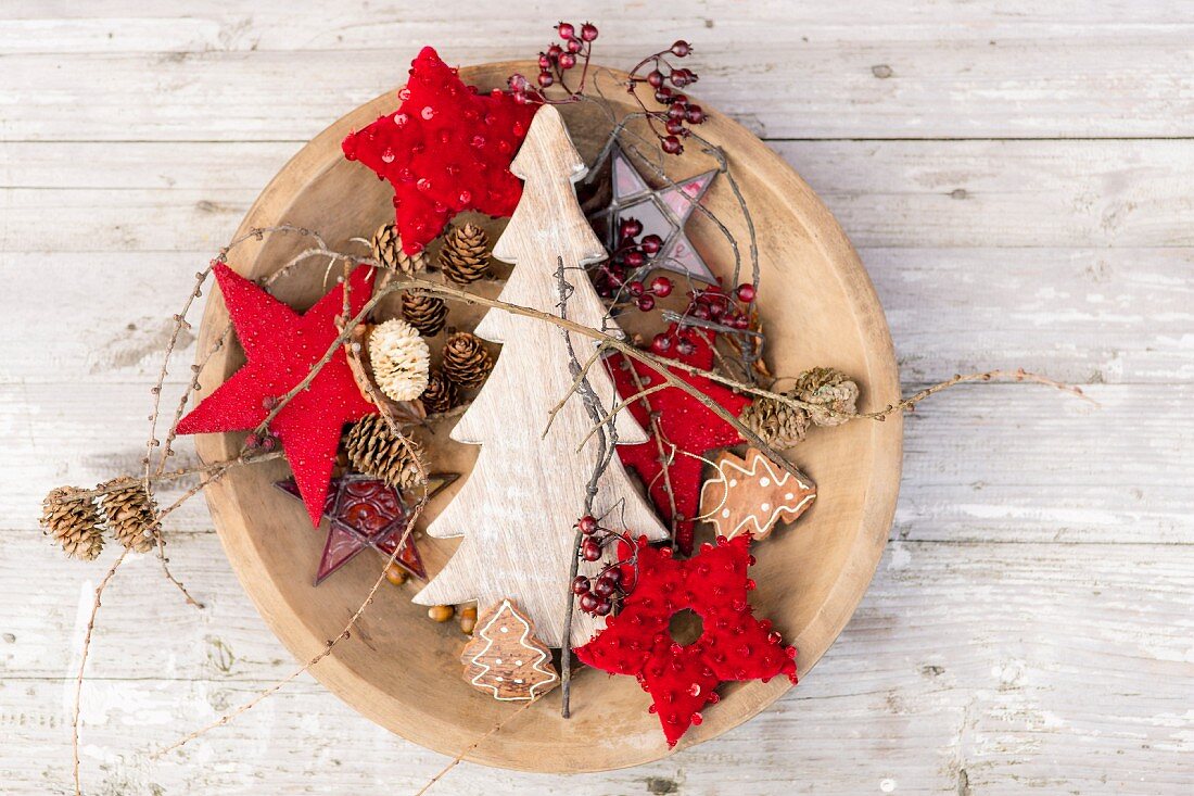 Red stars, wooden Christmas trees and pine cones in dish