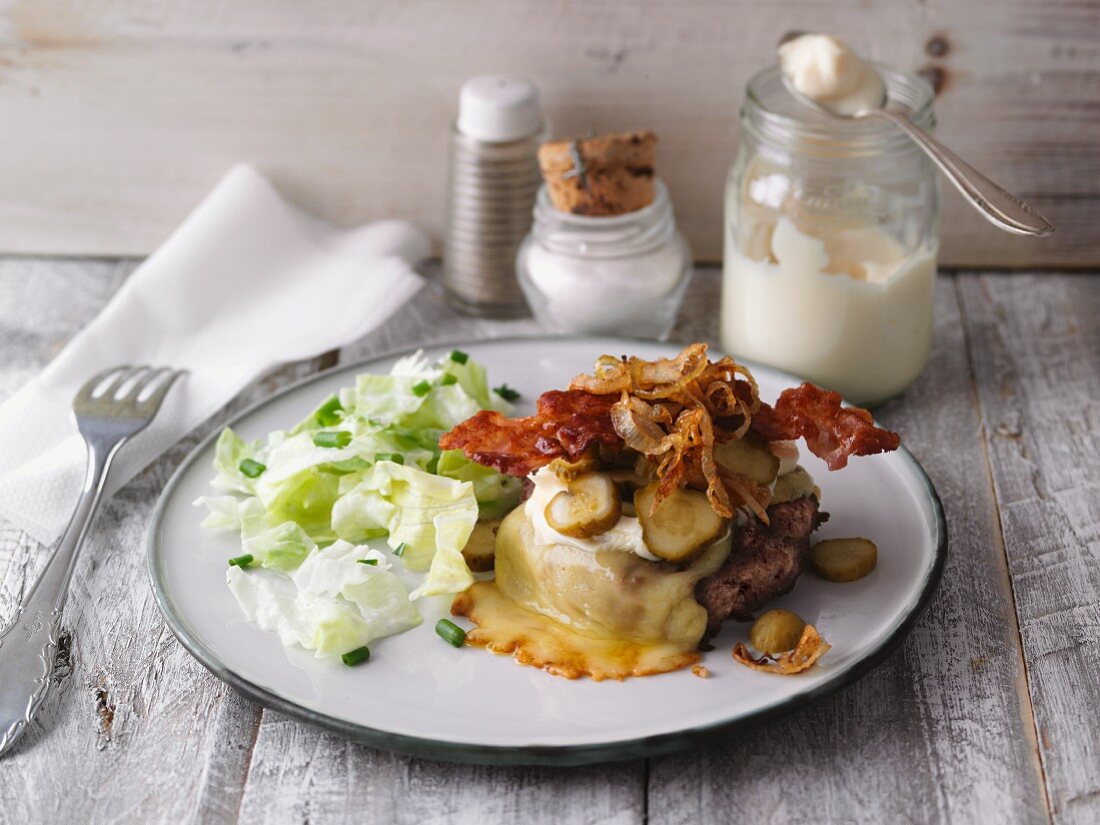 Gratinated burger with cornichons, bacon and roasted onions