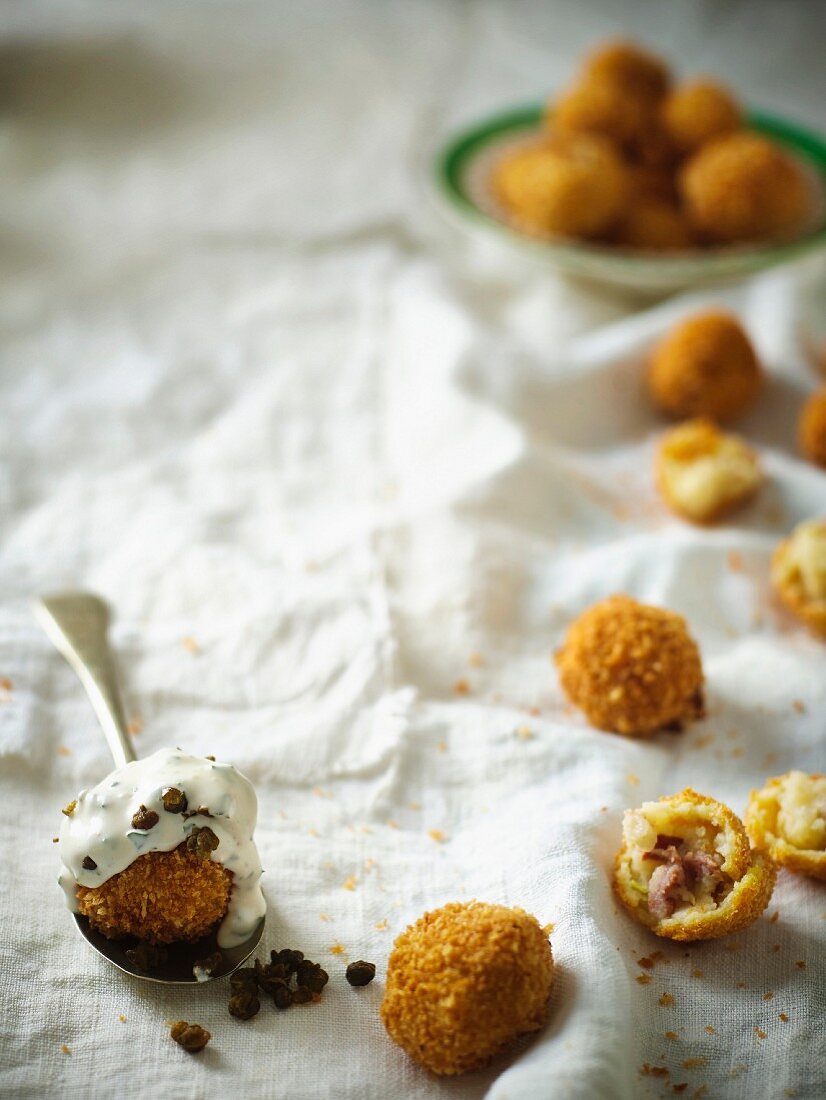 Crispy fried potato balls filled with bacon served with a quark dip