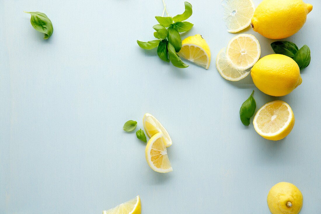 Lemons and basil on a white surface