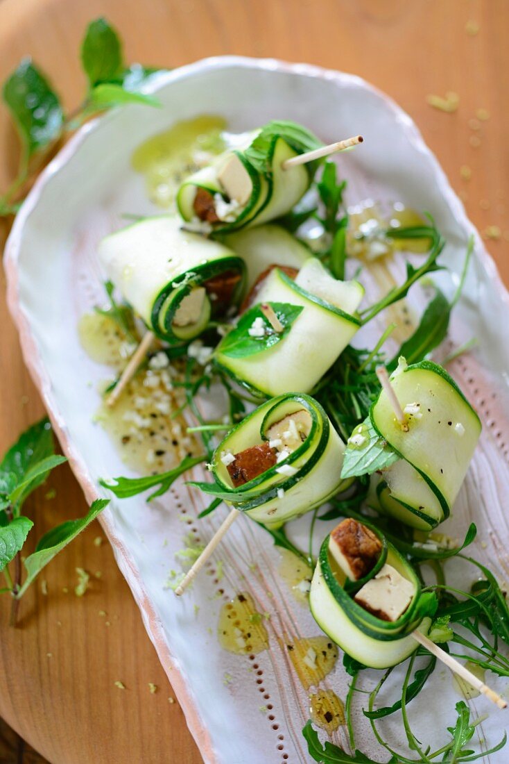 Stuffed courgette rolls on a bed of rocket