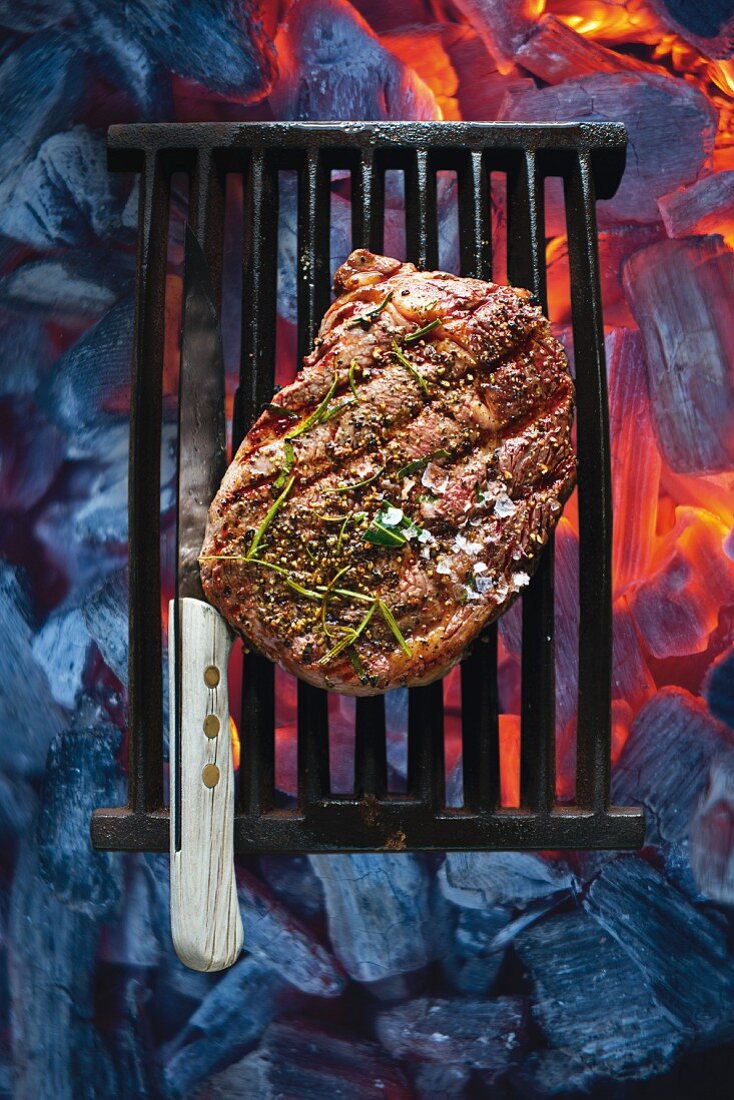 A peppered steak on a cooking grid