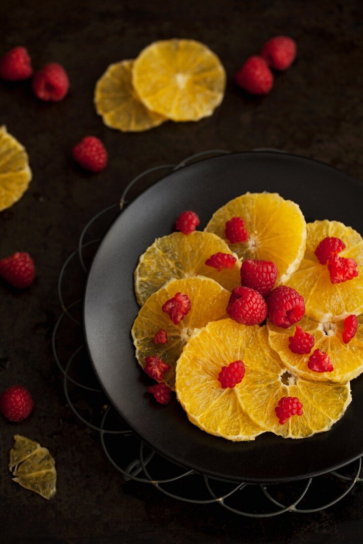 Ein Teller mit Orangenscheiben mit Himbeeren