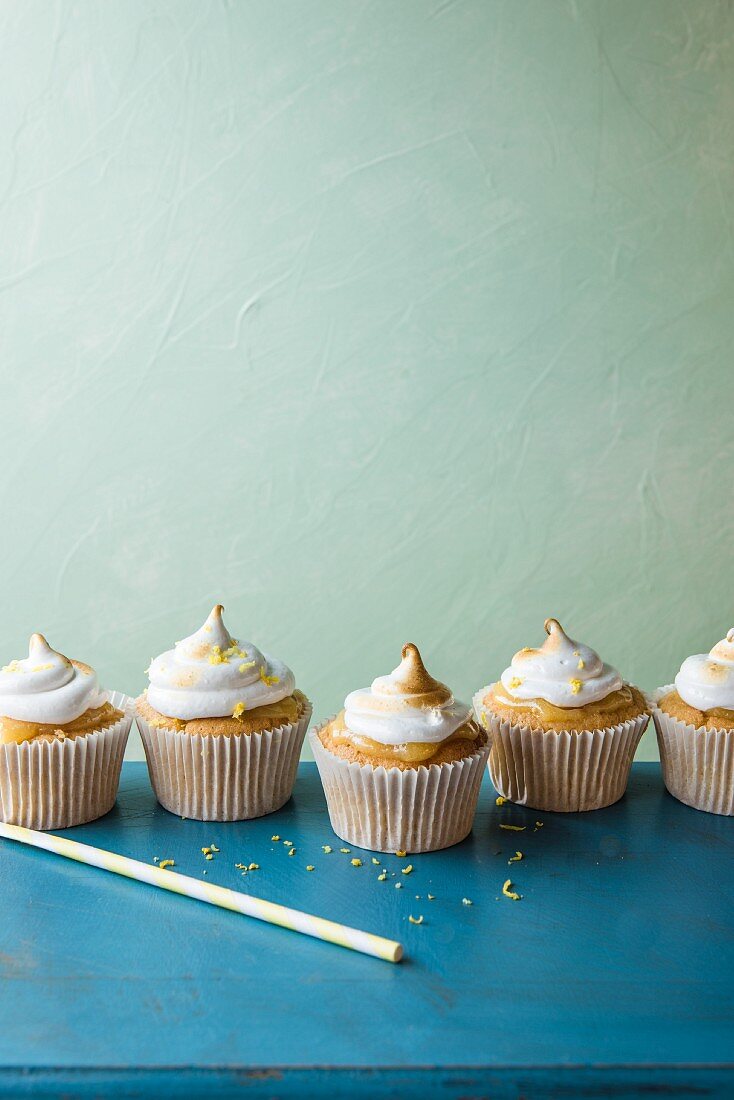 Lemon meringue cupcakes on a blue table