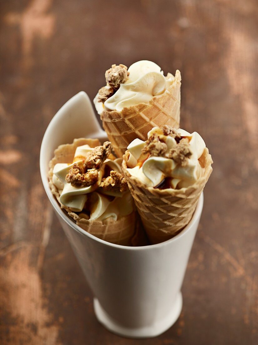 Mascarpone ice cream in cones with cereals and caramel sauce