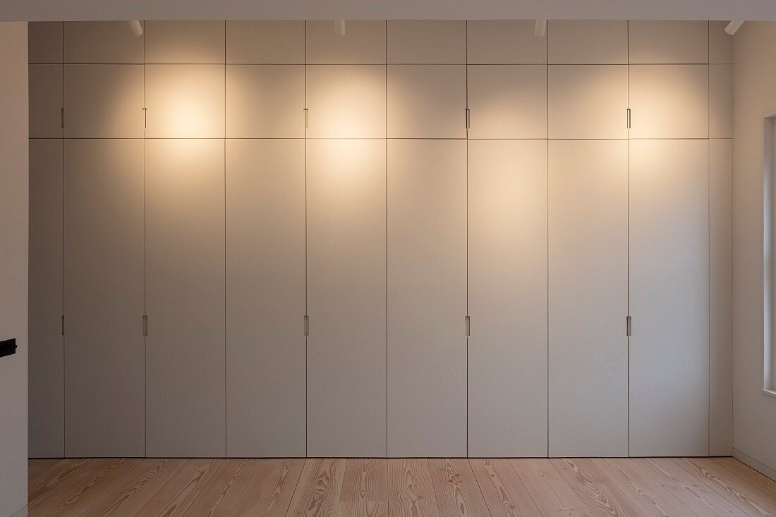 Beleuchtete raumhohe minimalistische Schrankwand
