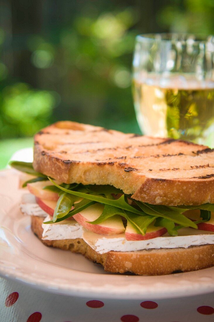 A sandwich with Brie, apples and dandelion leaves