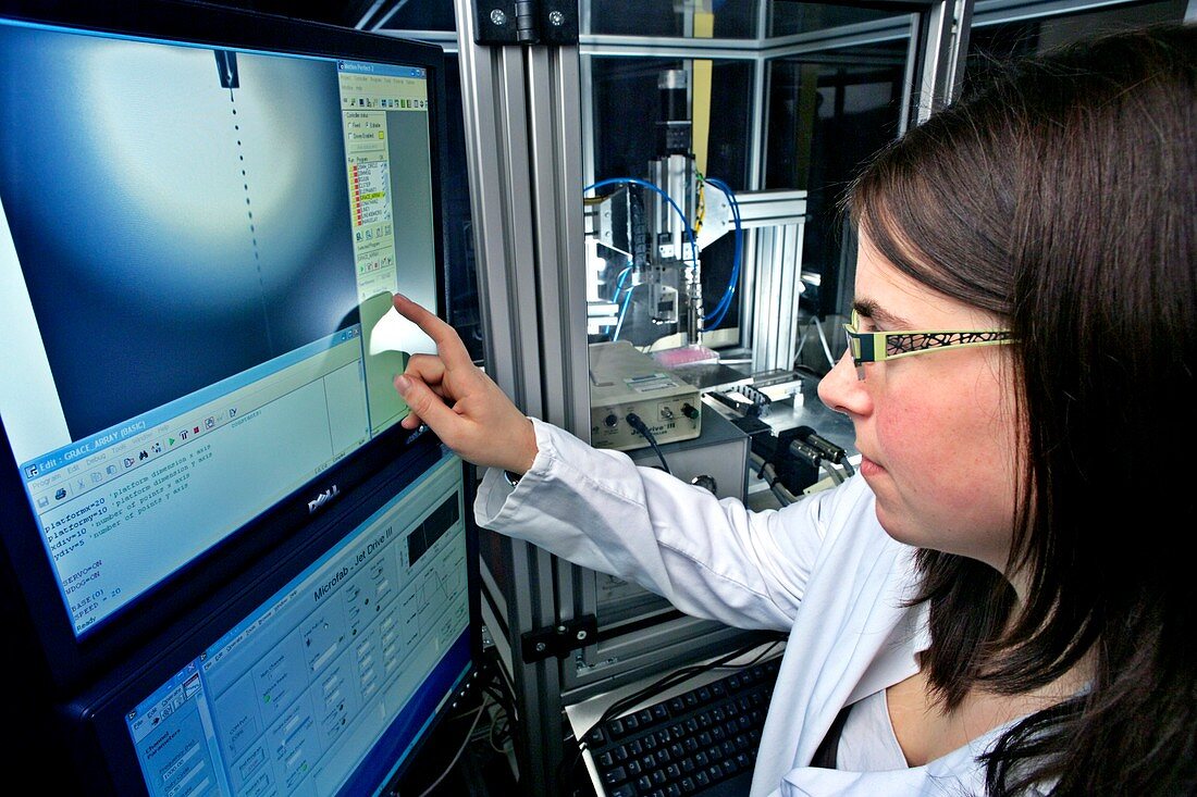 Researcher examining bioprinter on screen