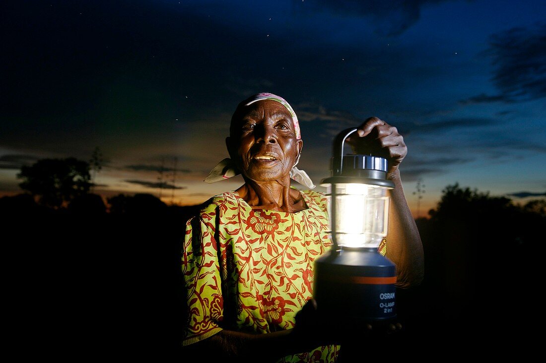 Woman holding a solar powered lamp,Kenya