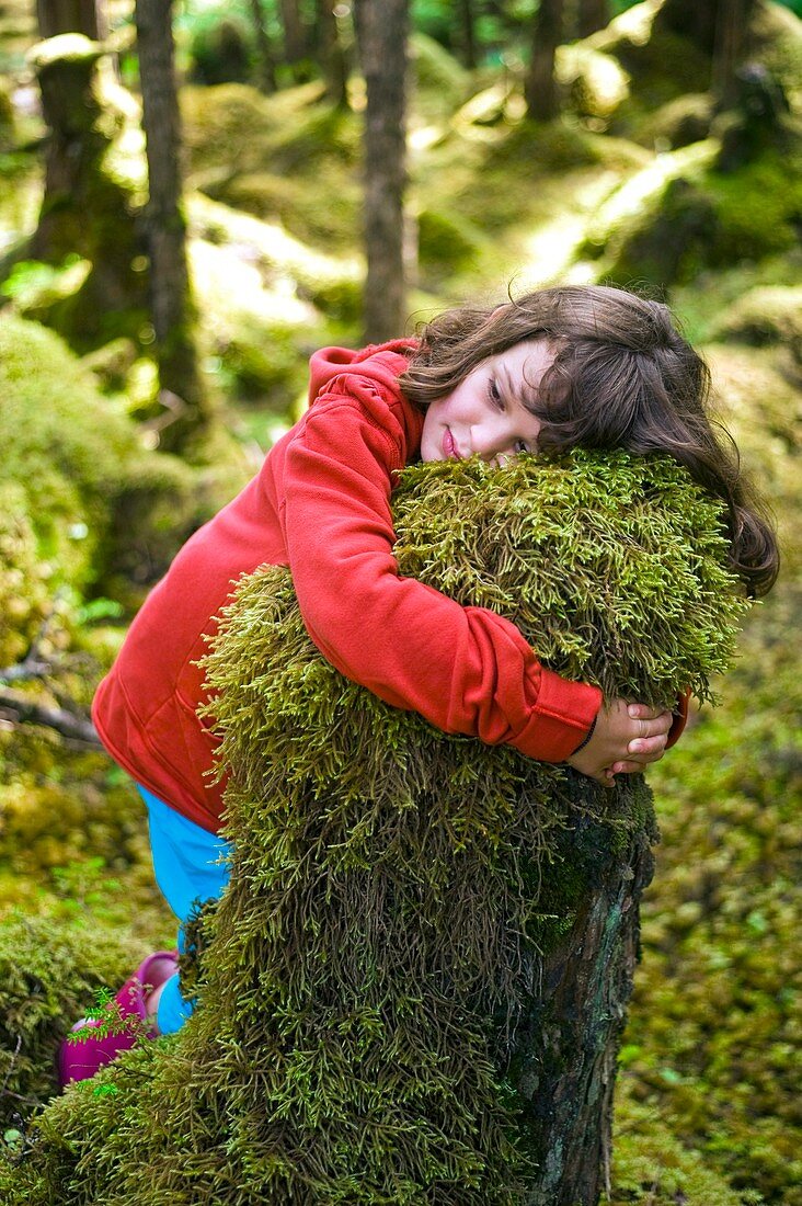 Girl hugging a tree stump