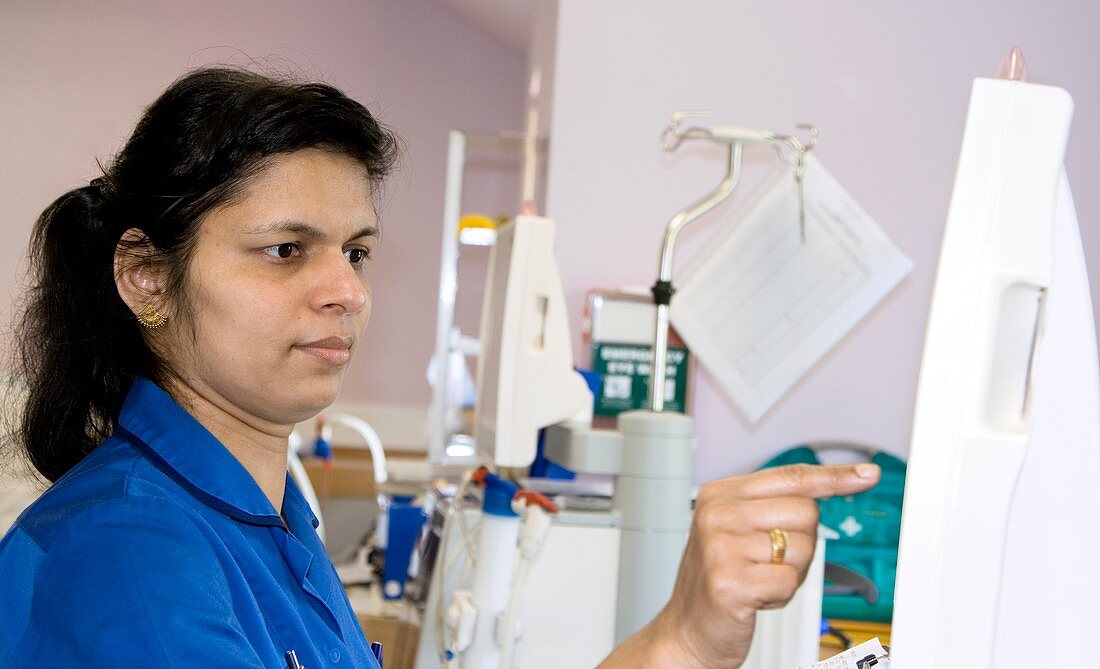 Nurse sets a dialysis machine