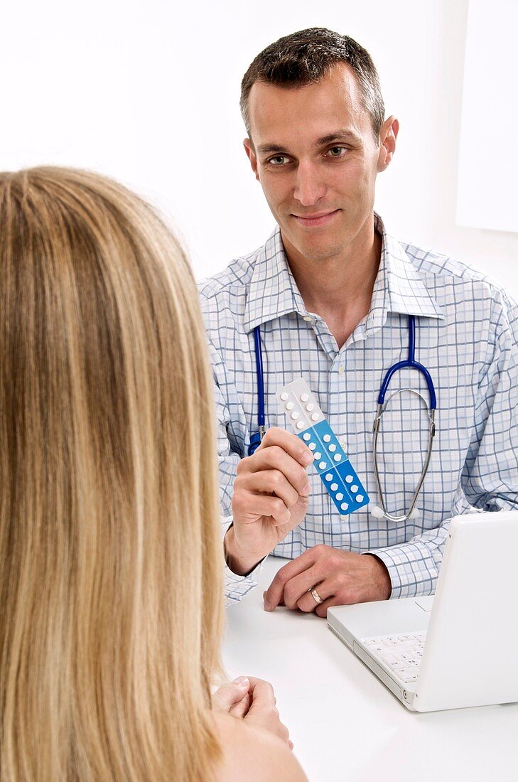 Doctor showing pills to a patient