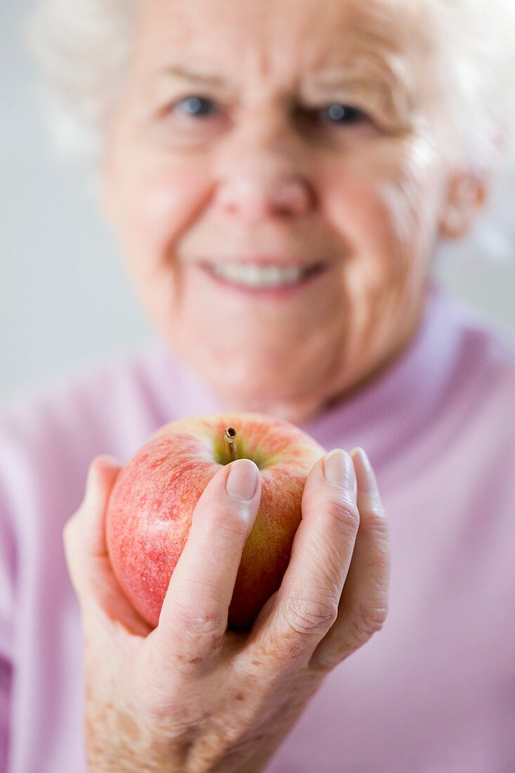 Elderly woman holding an apple