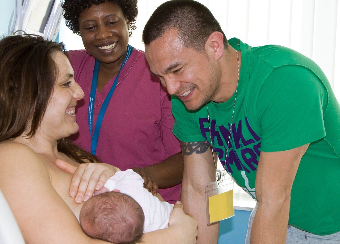 Nurse with parents and newborn baby girl