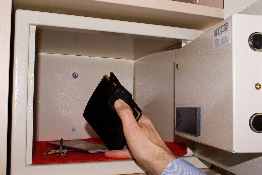 Man taking wallet from hotel in-room safe