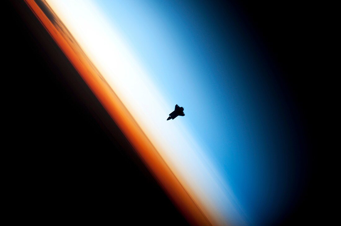 Space shuttle over Earth's horizon