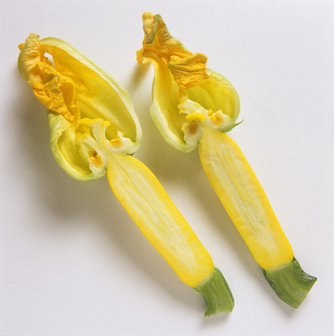 Halbierte gelbe Zucchini mit Blüten