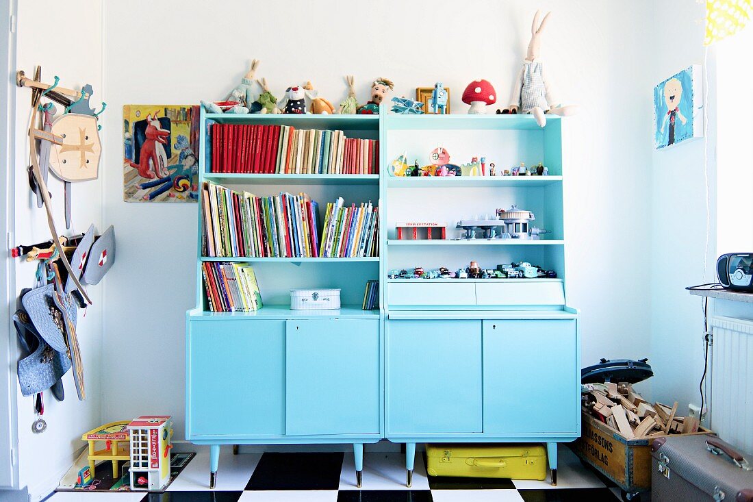 Dressers painted pale blue in child's bedroom with toy box and knights' armour