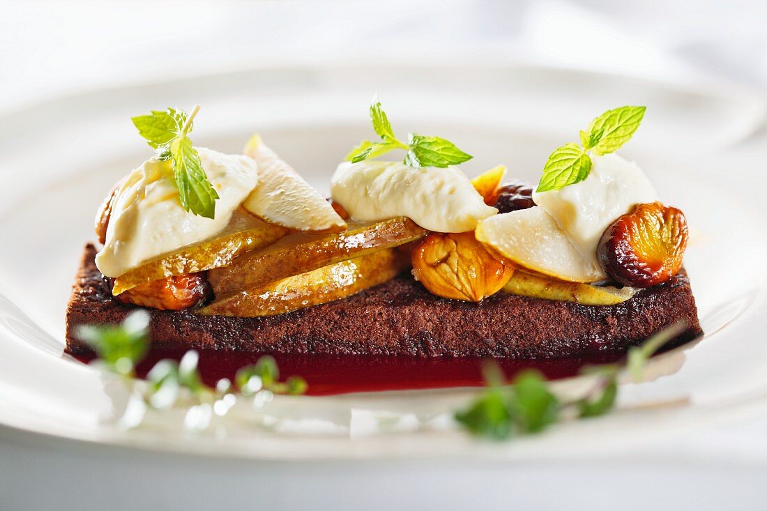 A brownie topped with pears, chestnuts and cream (Italy)