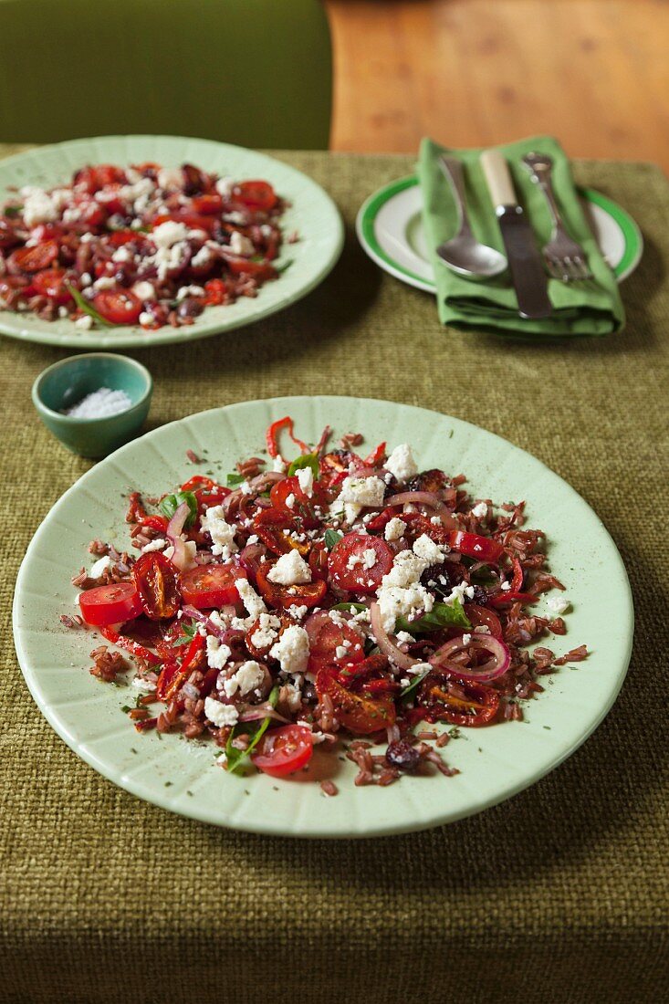 A red salad with rice, tomatoes, berries, herbs and spices