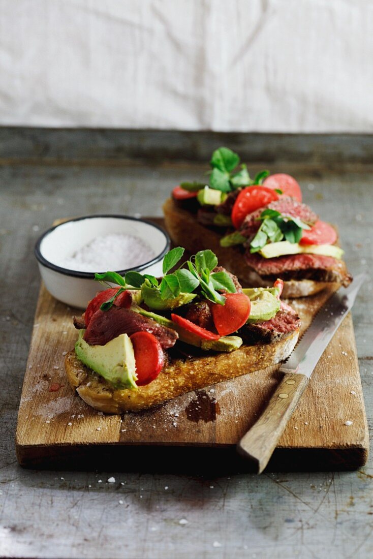 Grilled bread topped with steak, marinated radish and avocado