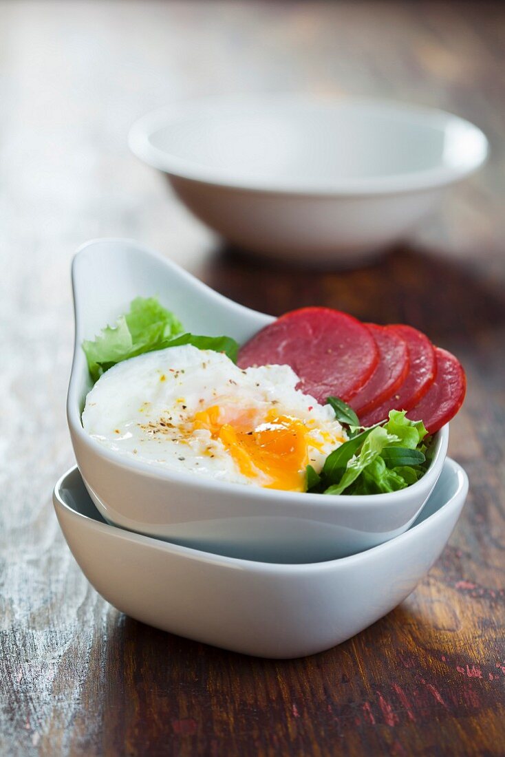 Blattsalat mit Wurst und pochiertem Ei