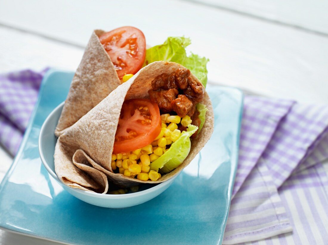 A tortilla wrap with beef, sweetcorn and vegetables