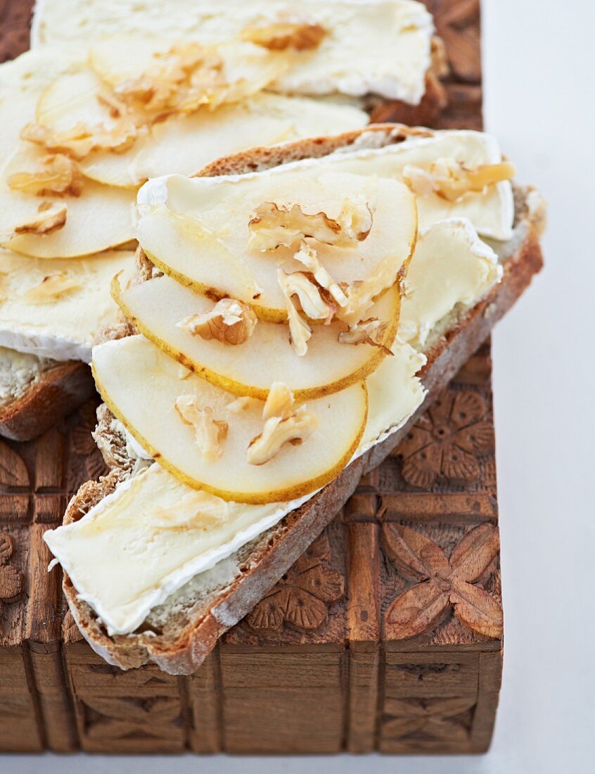 Slices of bread topped with Camembert, pears and walnuts