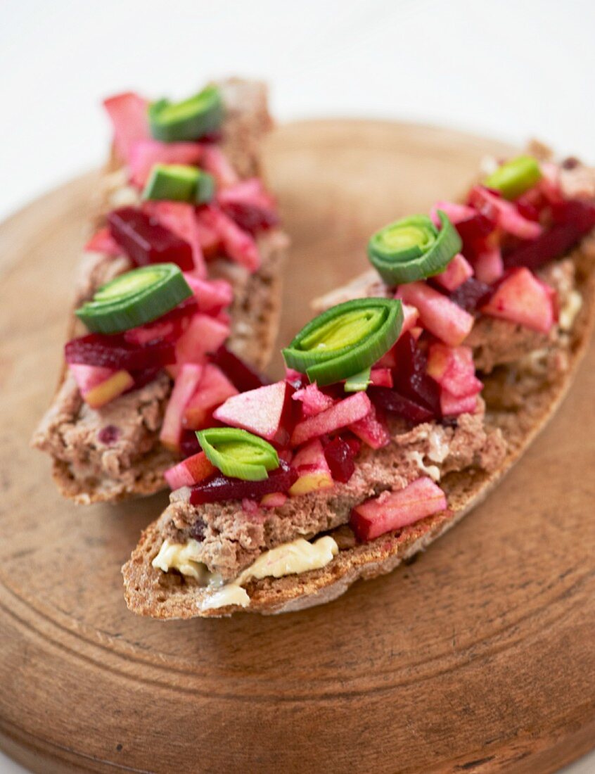 Slices of bread topped with liver pâté, beetroot and leek