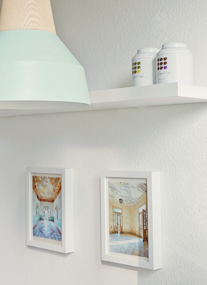 Framed photos of house interiors, tea caddies and metal lamp with wooden bulb socket by young designer