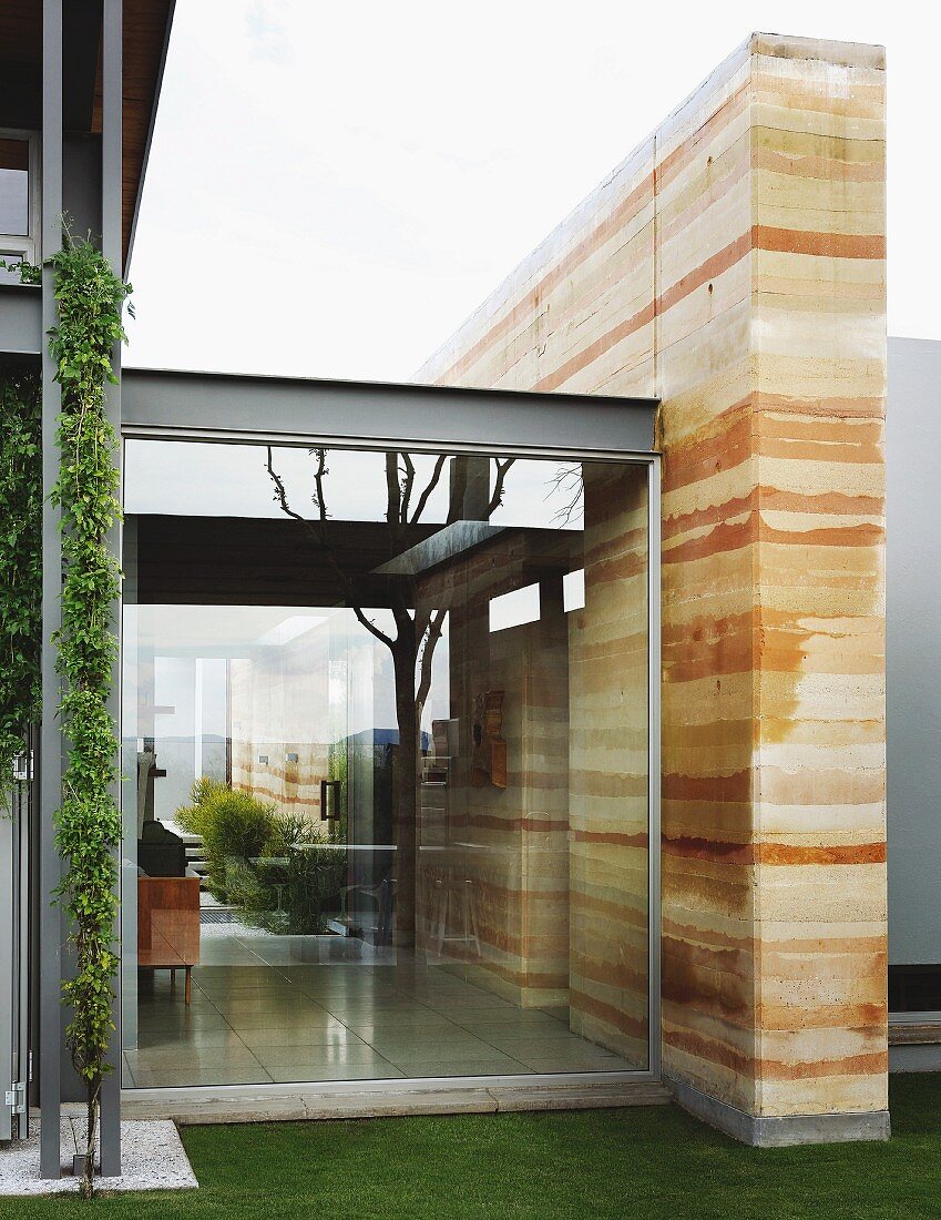 Modernes Wohnhaus mit Stahl-Glas-Fassade, Wandscheibe mit Lehmstruktur