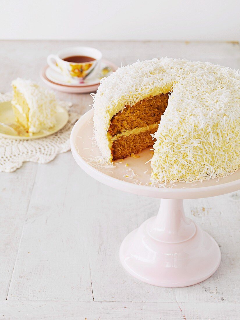 Hummingbird cake (mango and coconut cake with cream cheese), sliced on a cake stand