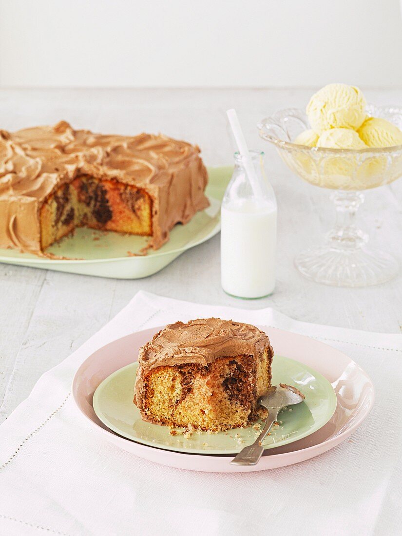 Sliced marble cake with chocolate buttercream, a slice on a plate