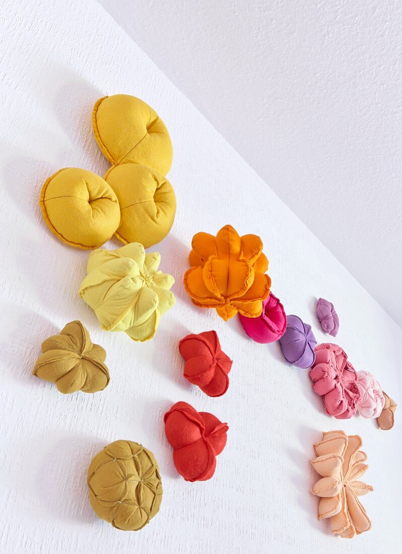 Work models of colourful pouffes and cushions pinned to wall