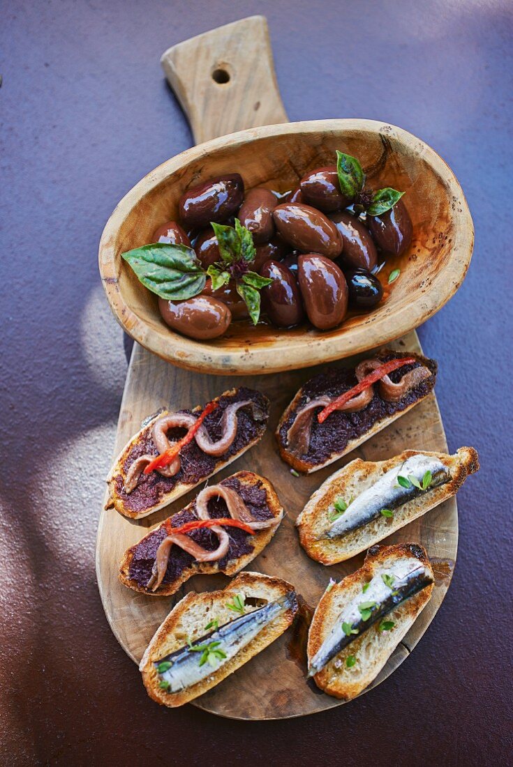 Mediterraner Vorspeisenteller mit Oliven und Crostini mit Sardinen und Anchovis