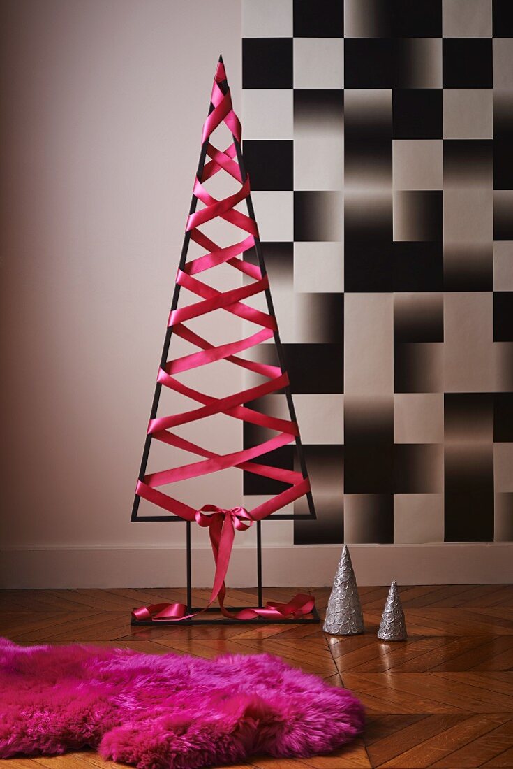 Moderner Christbaum aus Metall mit pinkem Seidenband