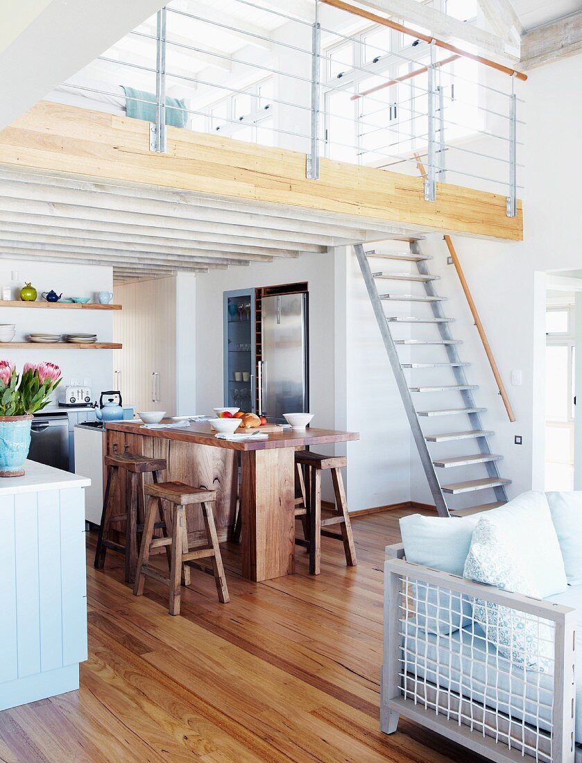 Rustic dining area below mezzanine in modern holiday home