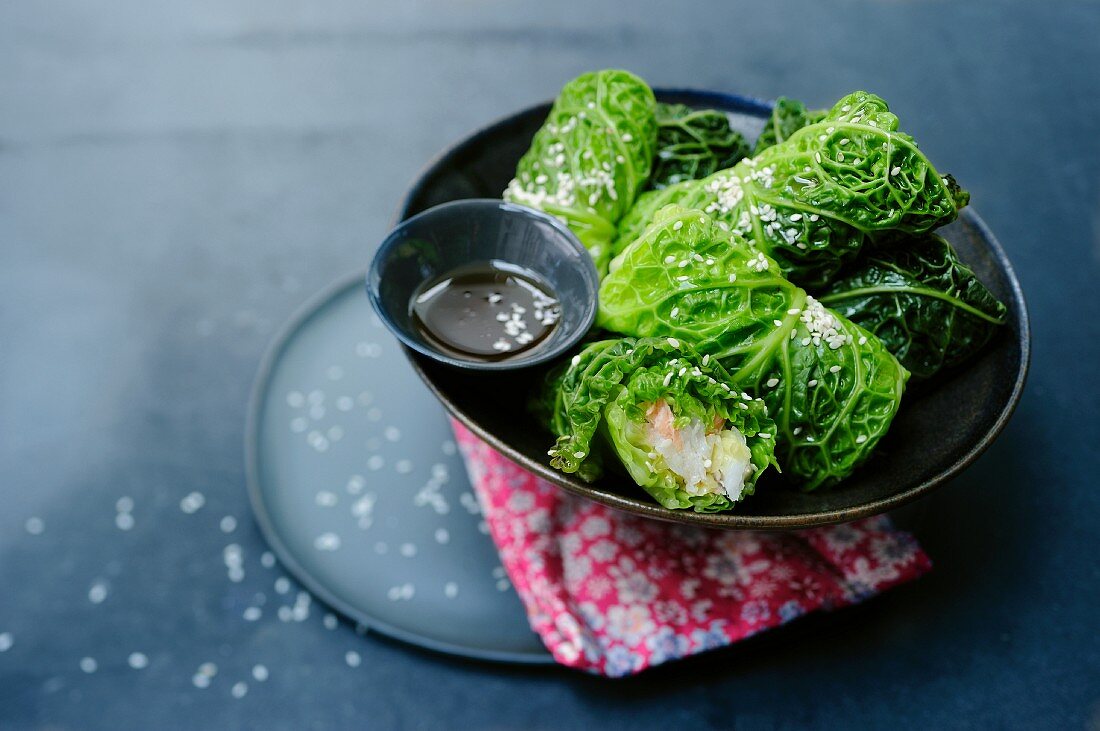 Savoy cabbage rolls filled with fish and sesame seeds (Asia)