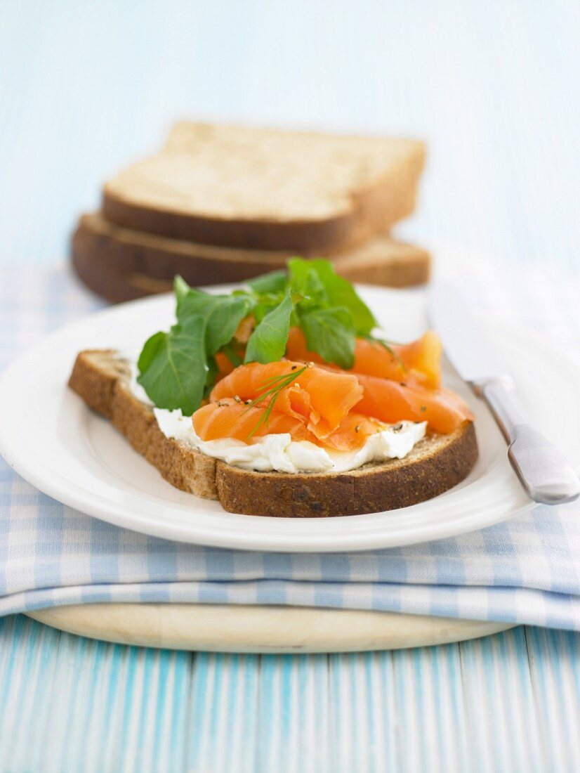 A slice of bread topped with cream cheese and salmon