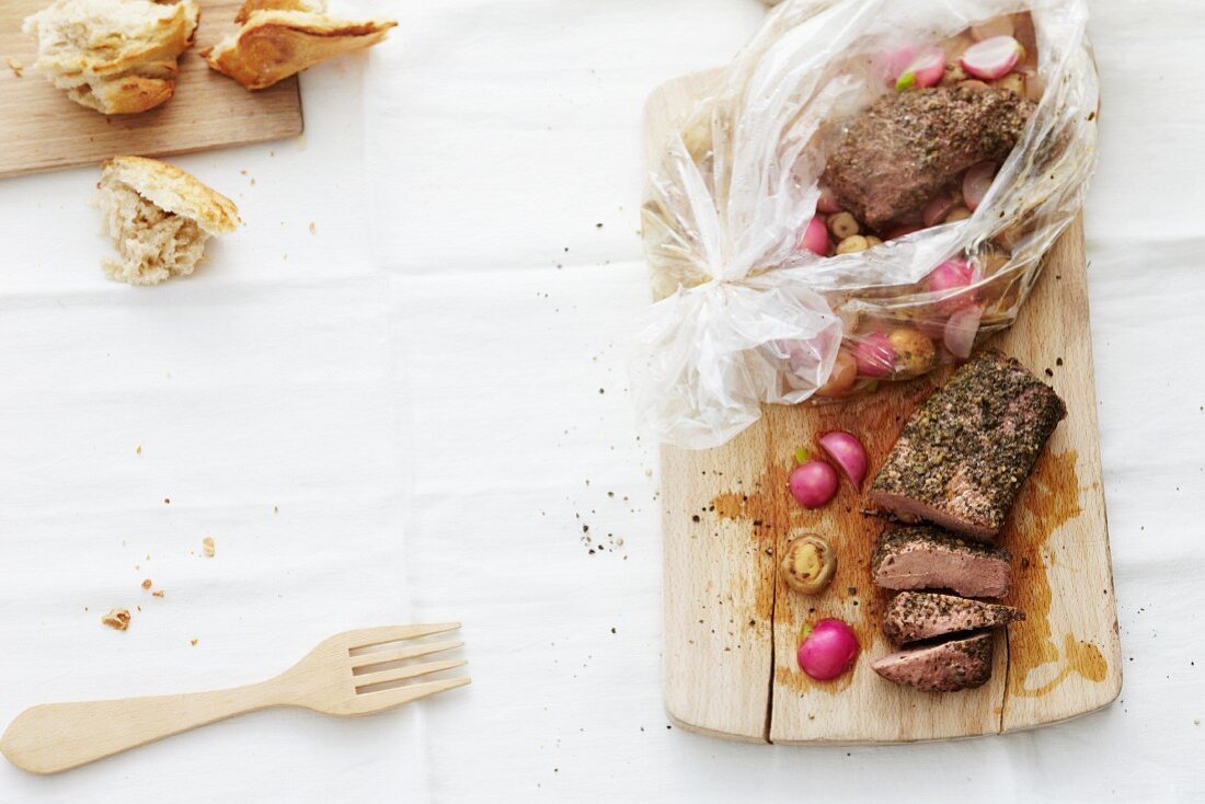 Lamb with a radish medley being removed from a roasting bag