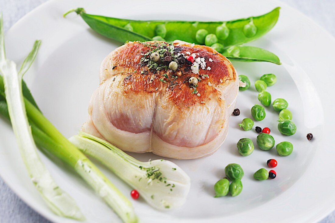 Kalbsfilet im Speckmantel mit zartem Frühlingsgemüse und Pfefferkörnern