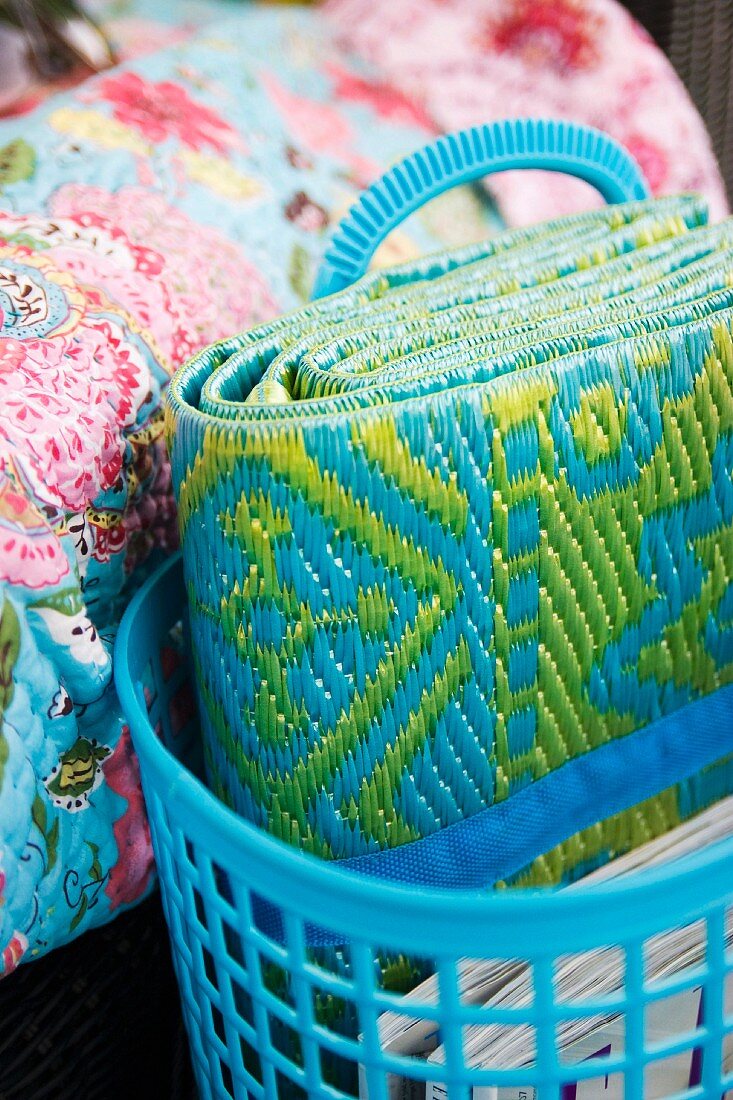 Patterned beach mat in pale blue plastic basket