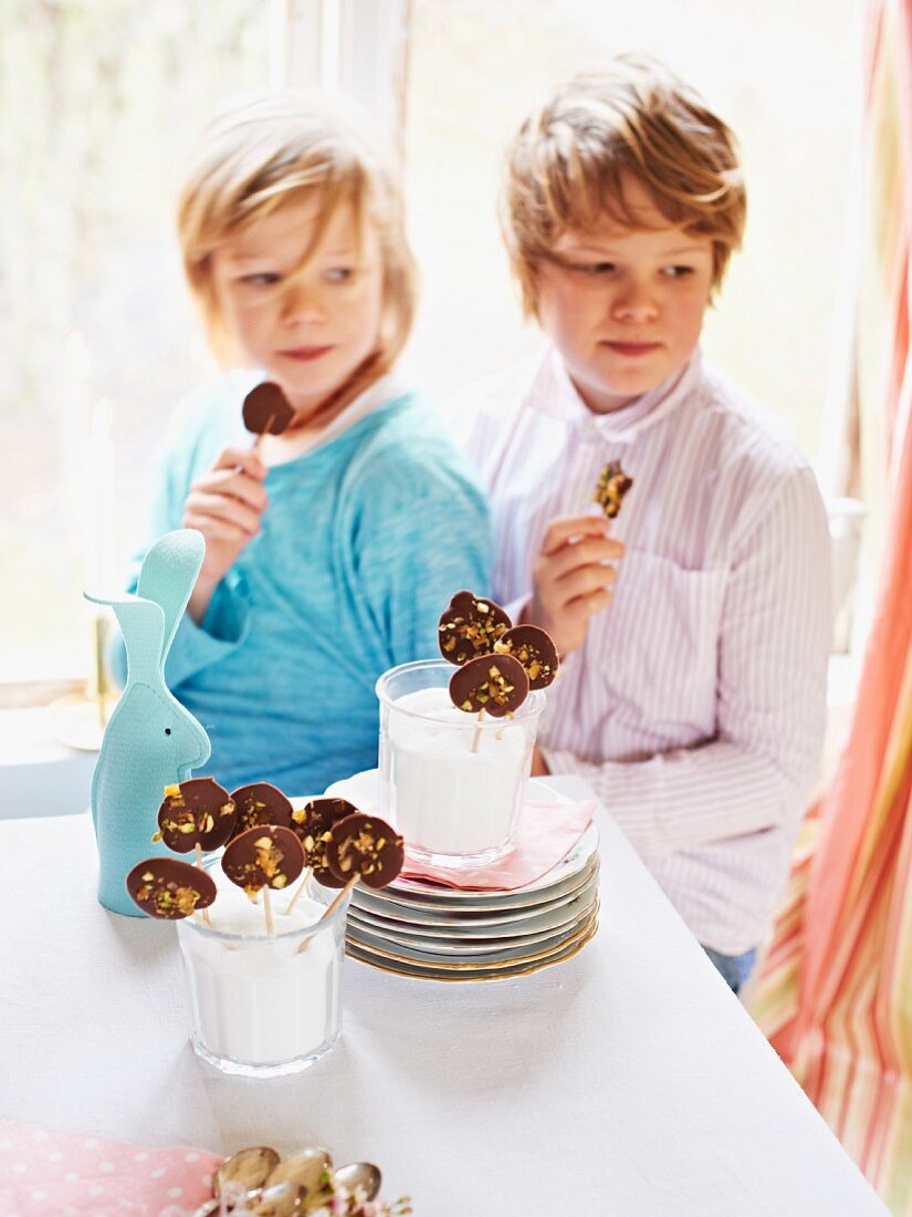 Kinder essen Schokolollies zu Ostern