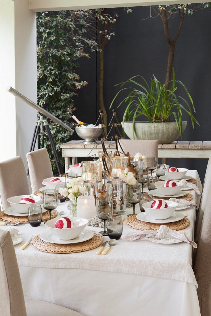 Table festively set with Christmas decorations on roofed terrace