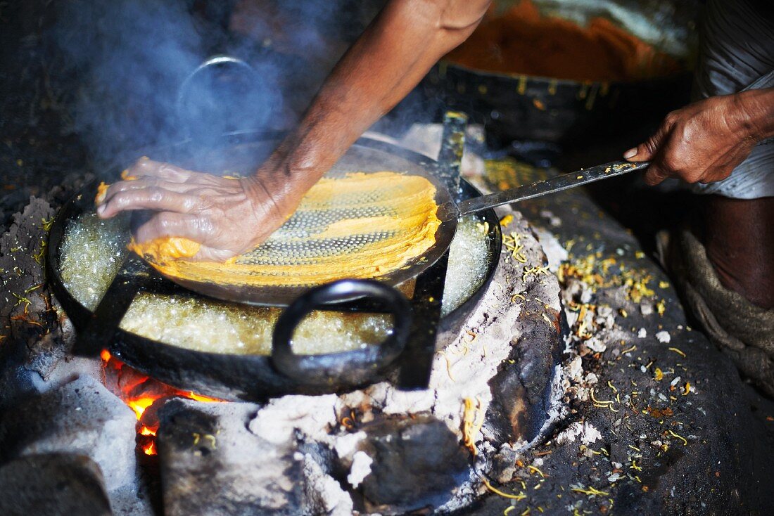 Mann beim Zubereiten von Omapodi (Kichererbsen- und Reismehl Snack, Indien)