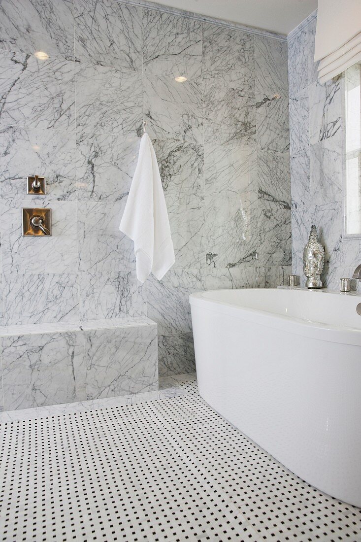 Bathroom with marble walls and bathtub; California; USA