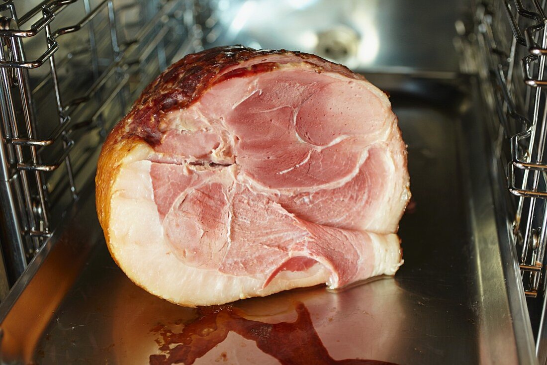 A glazed ham in an oven