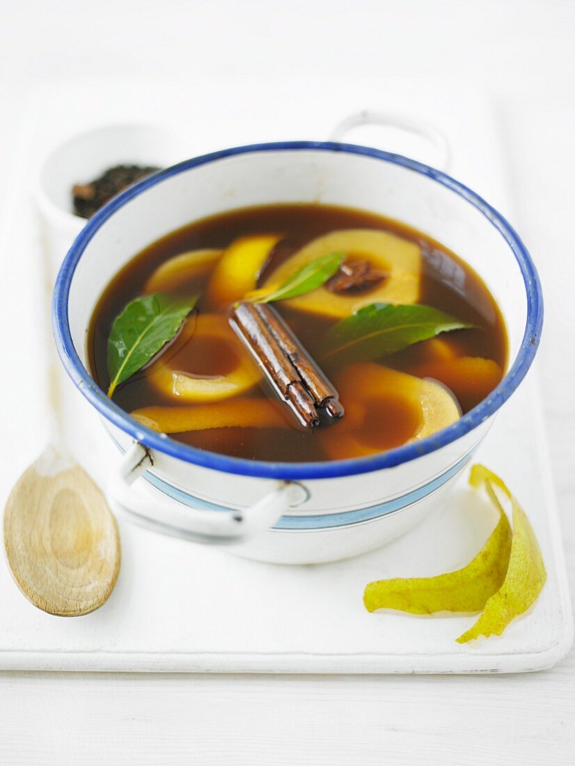 Pear compote in a spiced broth in an enamel bowl