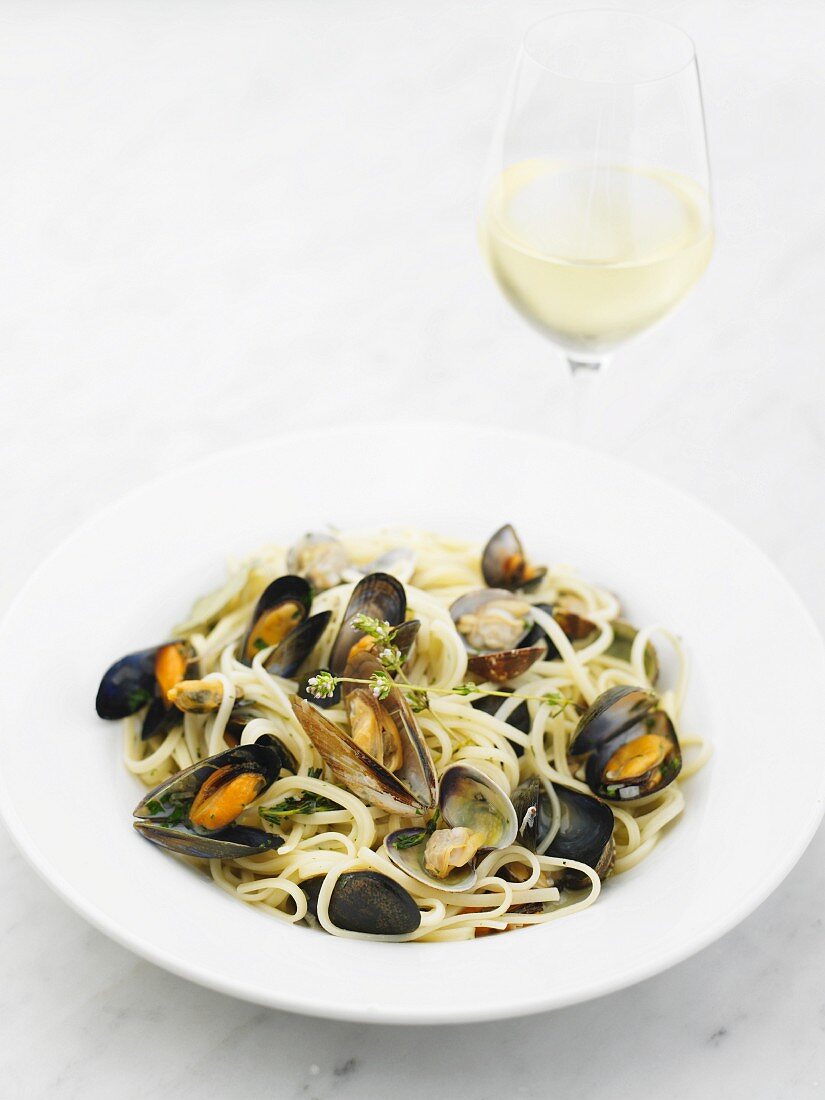 Spaghetti with mussels and clams on a white plate