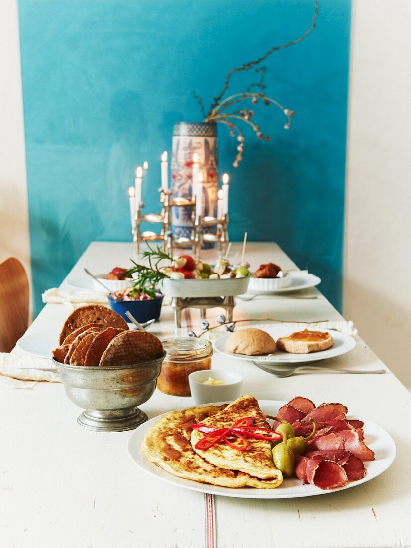 Gedeckter Tisch mit Pfannkuchen, Schinken und Knäckebrot